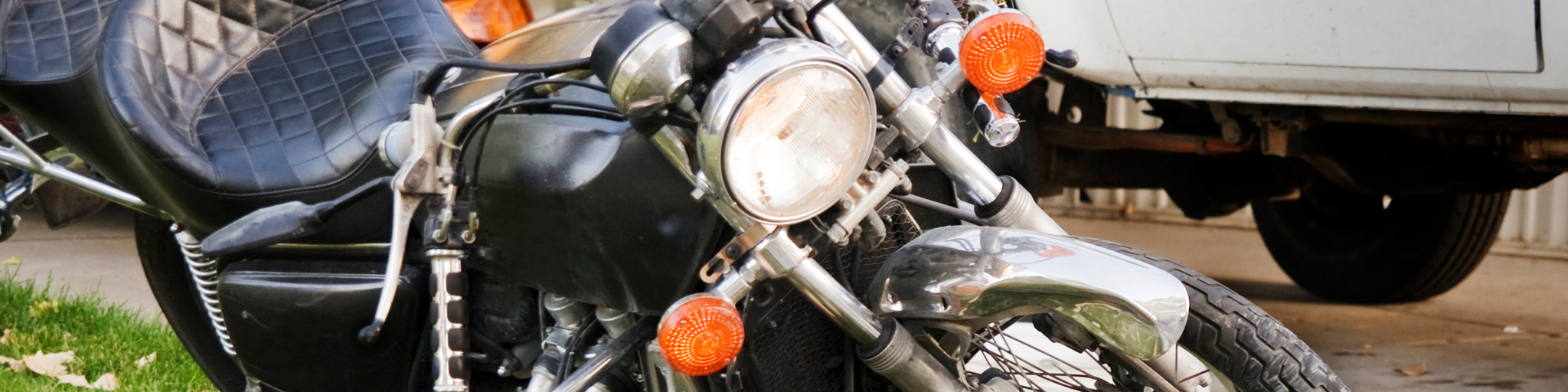 A motorcycle resting on its side near a curb, representing a common learning moment for riders and the importance of building confidence and proper handling skills.