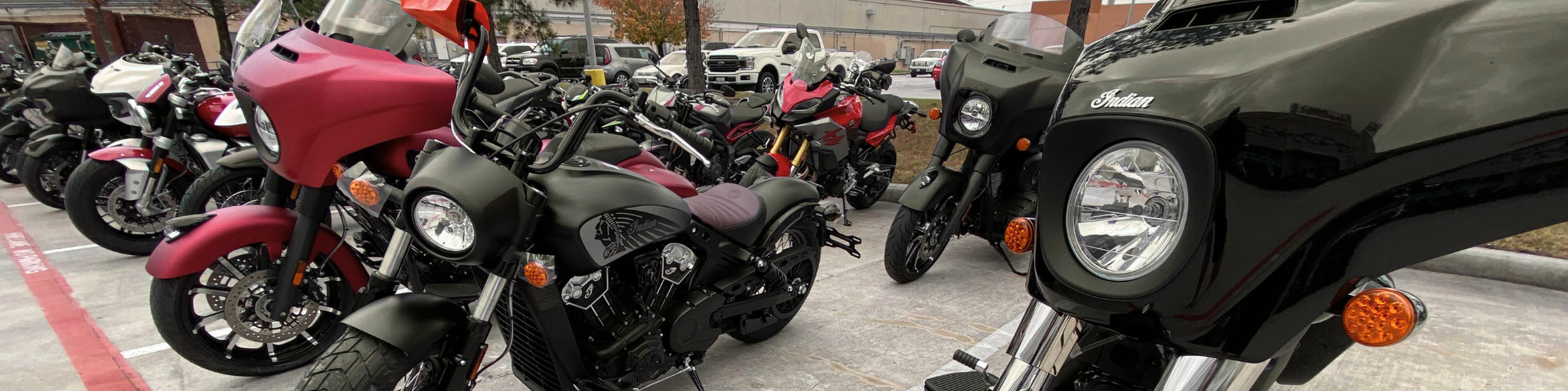 A row of new Indian Motorcycles lined up at Woodlands Premium Motorcycles, representing the process of selecting and ordering a motorcycle from available inventory.