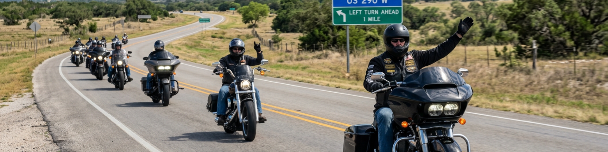 Group of motorcycle riders in formation on US 290 in the Texas Hill Country, with lead riders exchanging a wave - a classic hand signal and tradition of the riding community.