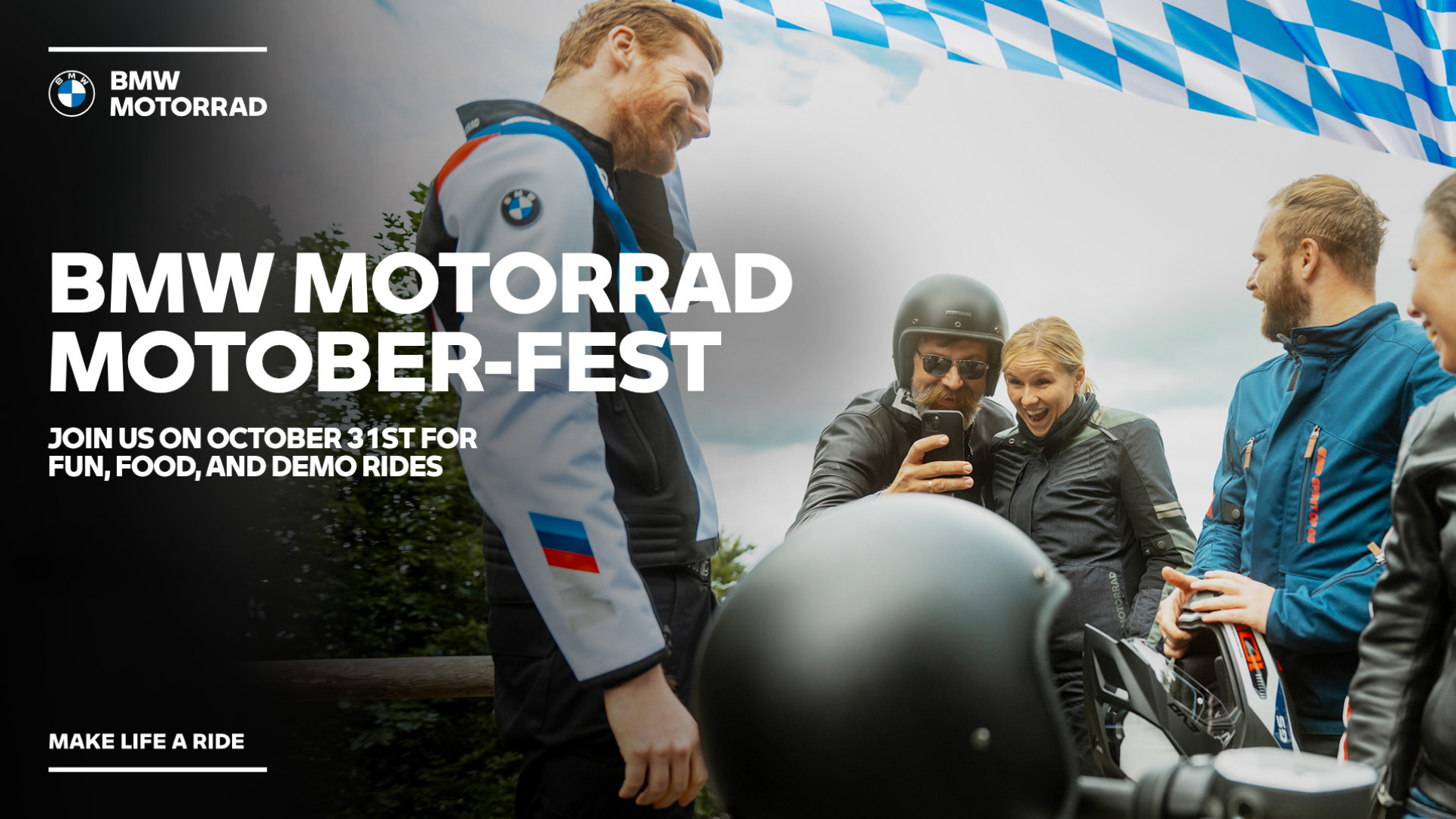 Riders gather beneath a blue-and-white Bavarian flag in a BMW Motorrad Motober-Fest banner inviting guests to enjoy food, fun, and demo rides on October 31.
