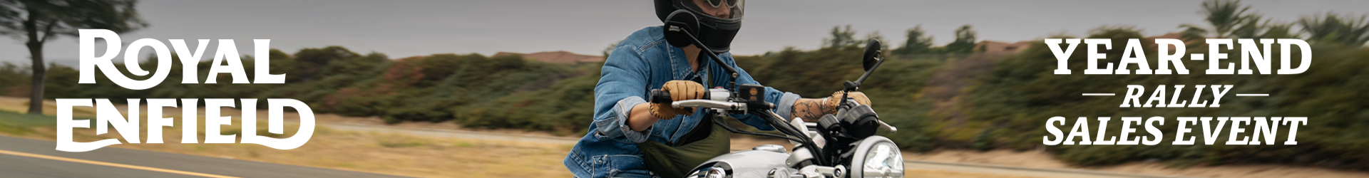 Rider in a denim jacket riding a Royal Enfield motorcycle on a sunny road during the Royal Enfield Year-End Rally Sales Event